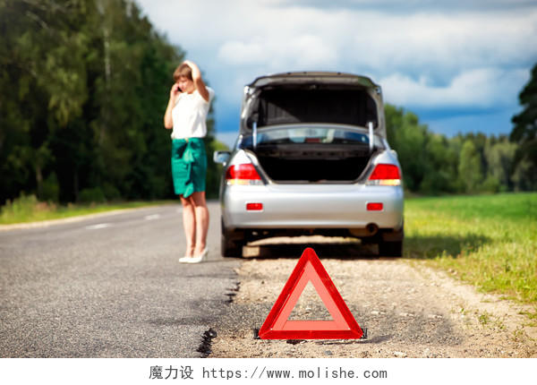 靠近三角形警告标志时妇女在与后面的汽车抛锚后呼叫救援